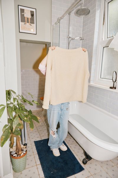 a person doing hand washing laundry in a bathroom