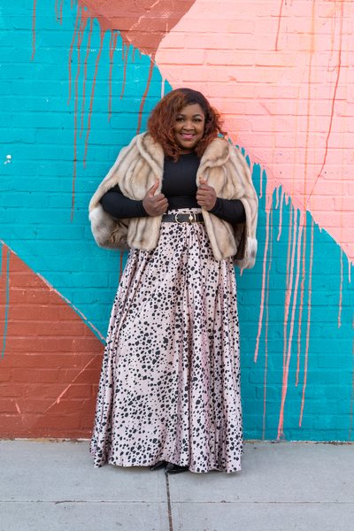 Stylist and fashion editor Karis Battle, 35, in a vintage fur store, black shirt, and dotted maxi skirt