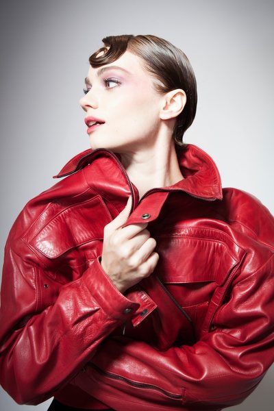 a model wearing a 1980s vintage red leather jacket by Claude Montana