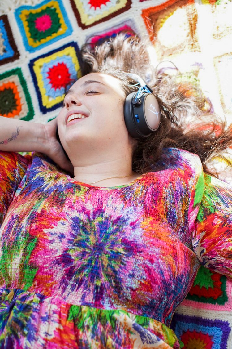 a young woman on the floor listening to headphones