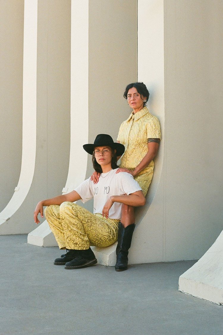 A queer couple Genevieve Marruffo, 24, and Em Rodriguez, 40, in matching outfits.