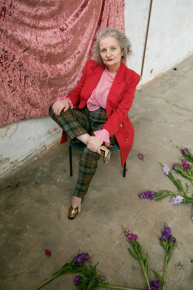 Stylist Karen James-Welton, 55, aka Fabulous Miss K in a vintage red blazer, pink blouse, and green-and-brown plaid pants, and golden shoes.